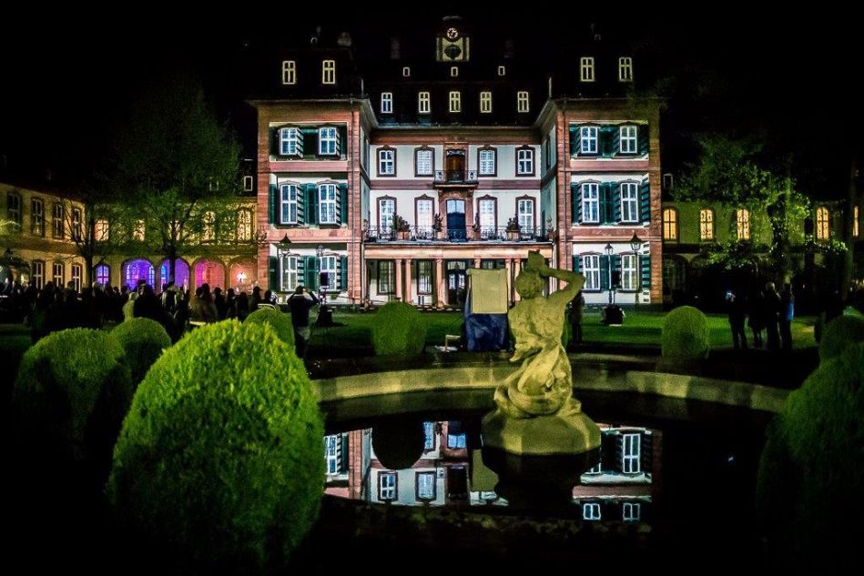 Der erleuchtete Bolongaropalast zur Nacht der Museen bei Dunkelheit, Teich mit Brunnen im Vordergrund